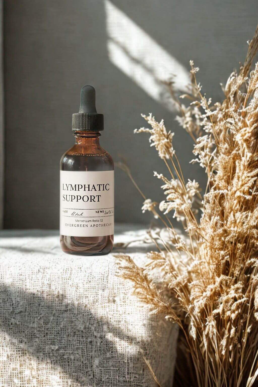 evergreen apothecary lymphatic support herbal tincture with dried botanicals in warm sunlight