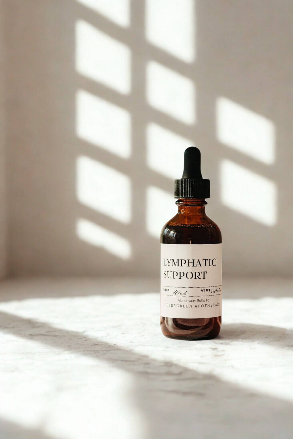 evergreen apothecary lymphatic support herbal tincture in amber dropper bottle with window light