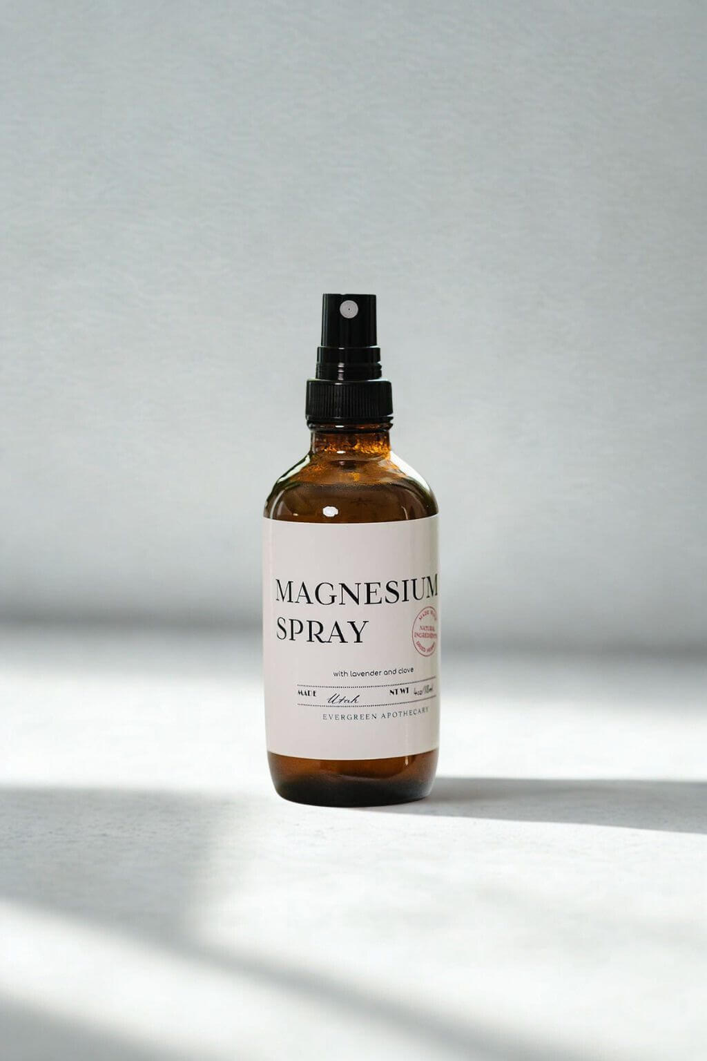evergreen apothecary magnesium spray bottle on minimal light background
