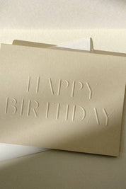 Neutral birthday card with envelope styled in warm natural light
