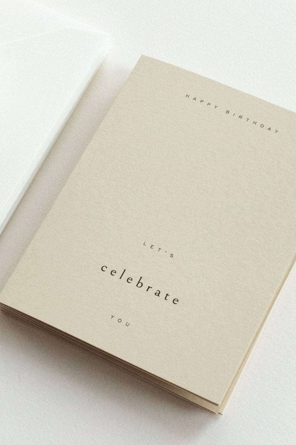 Stack of neutral-toned birthday cards with simple typography and soft texture