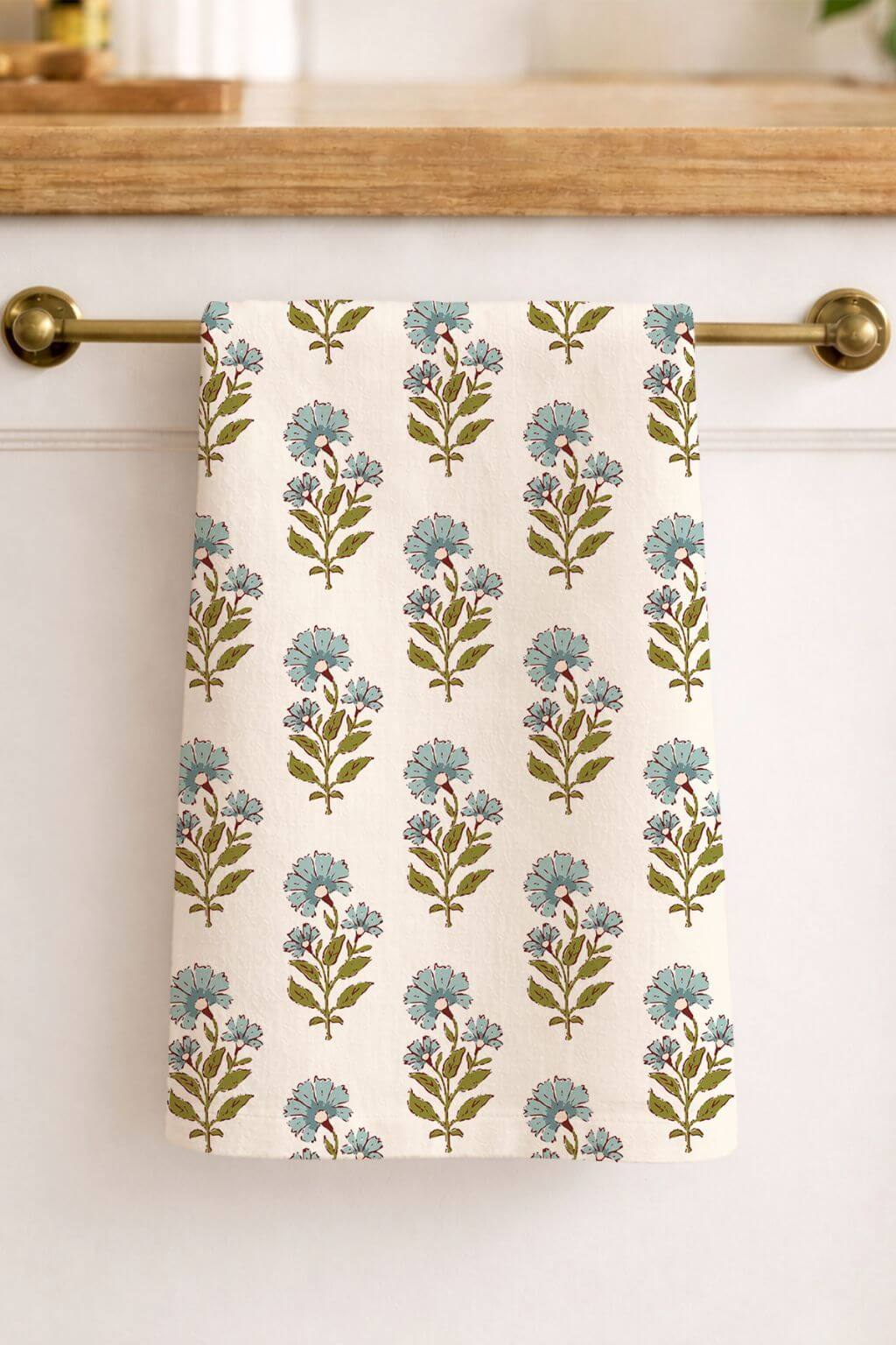 Floral marigold patterned towel hanging on a kitchen cabinet handle.