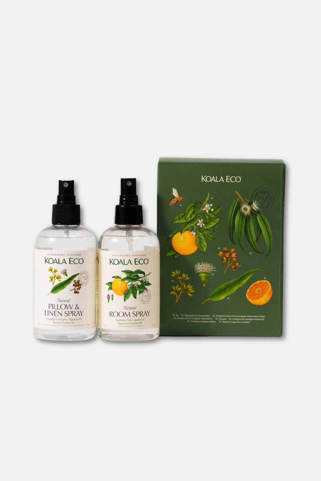 A bottle of Koala Eco Natural Pillow + Linen Spray and Natural Room Spray with a dark green gift box featuring botanical drawings