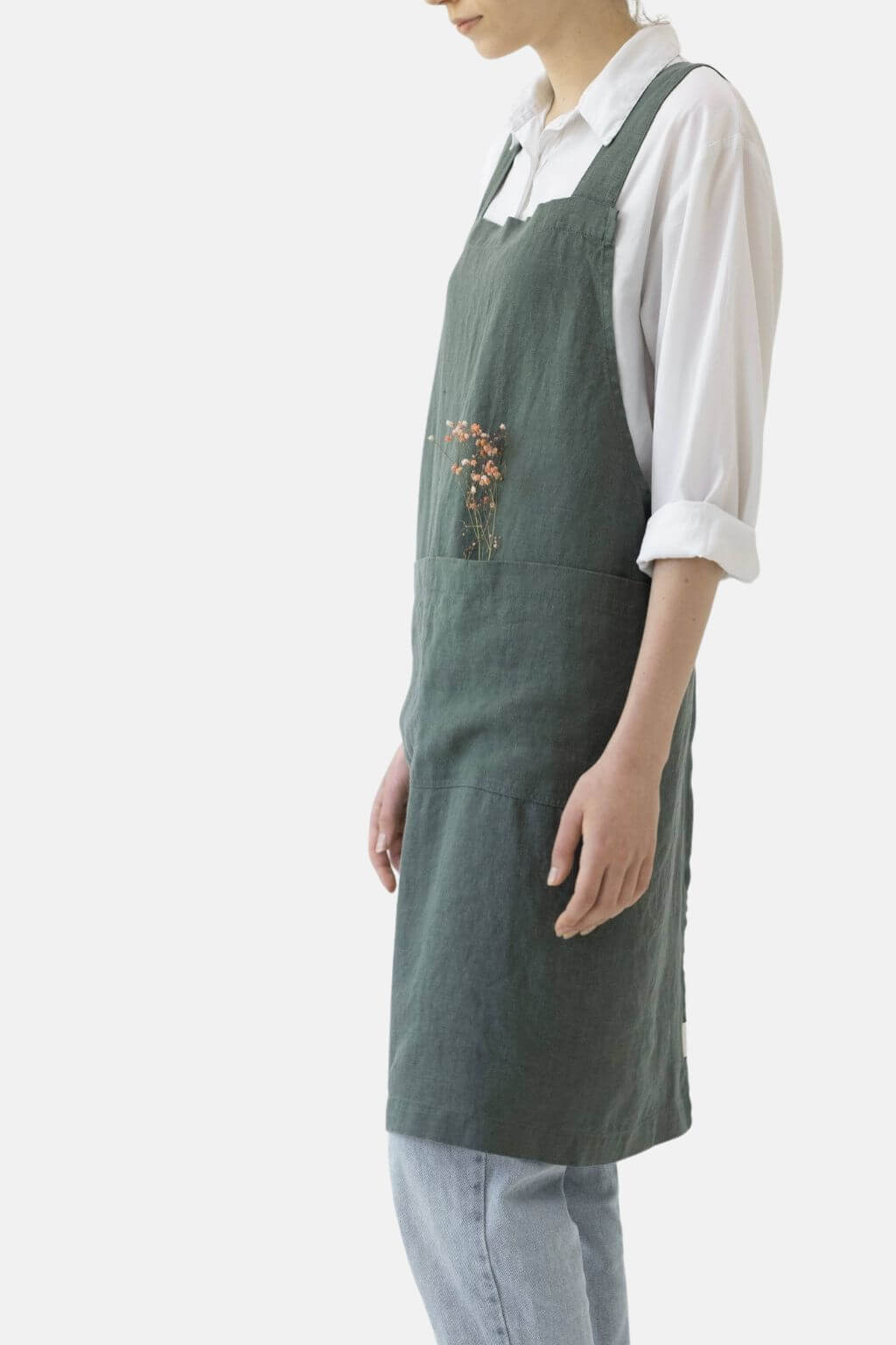 Side view of forest green linen Japanese cross back apron
