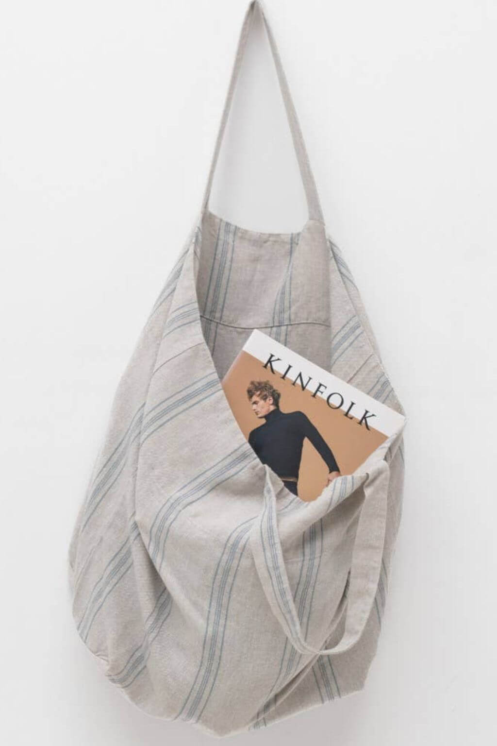 Oversized French stripe linen shoulder bag holding a book and daily essentials