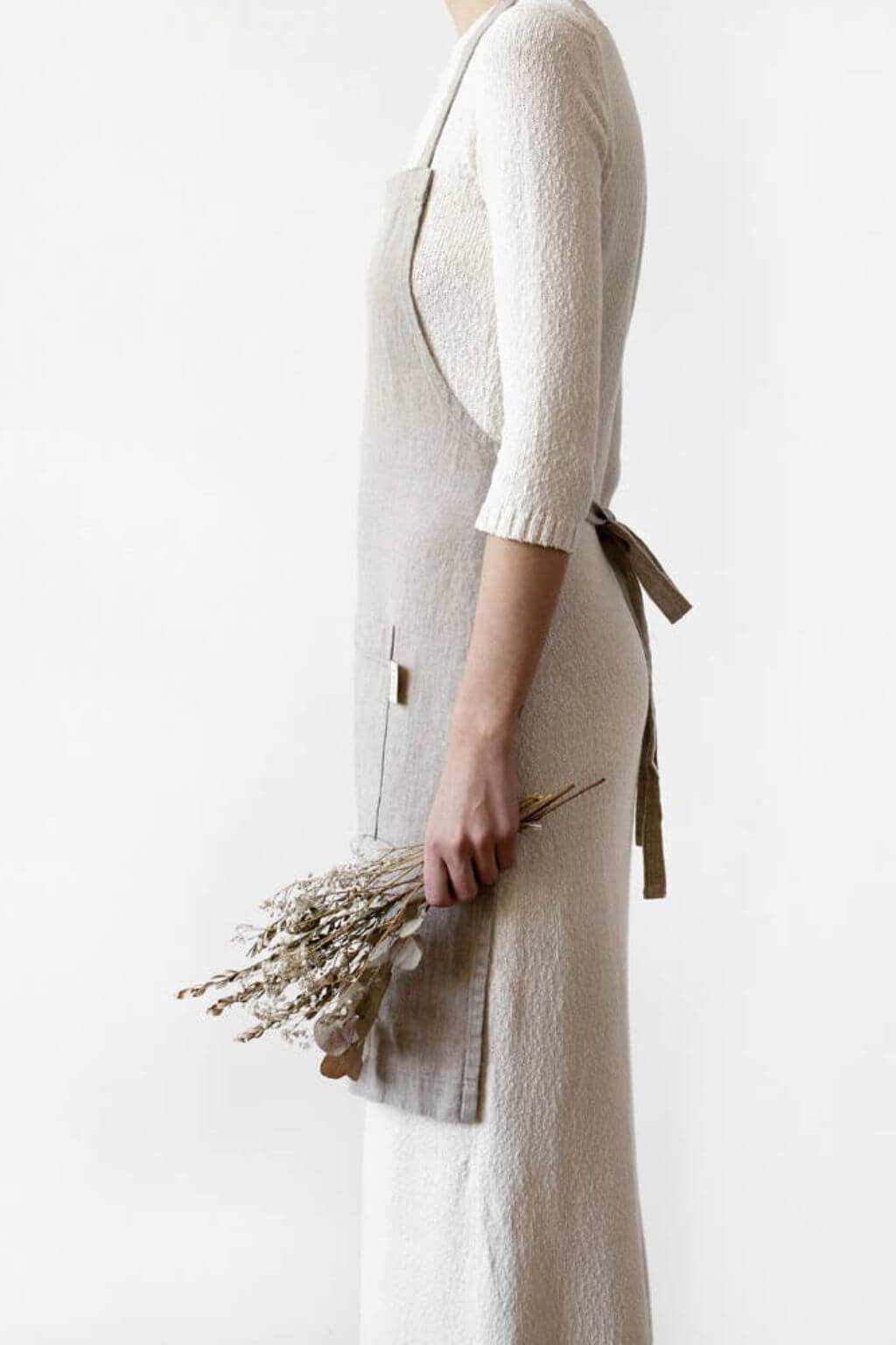 Side view of natural linen apron with adjustable waist ties