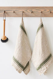 Green stripe heritage linen kitchen towels hanging beside wooden dish brush