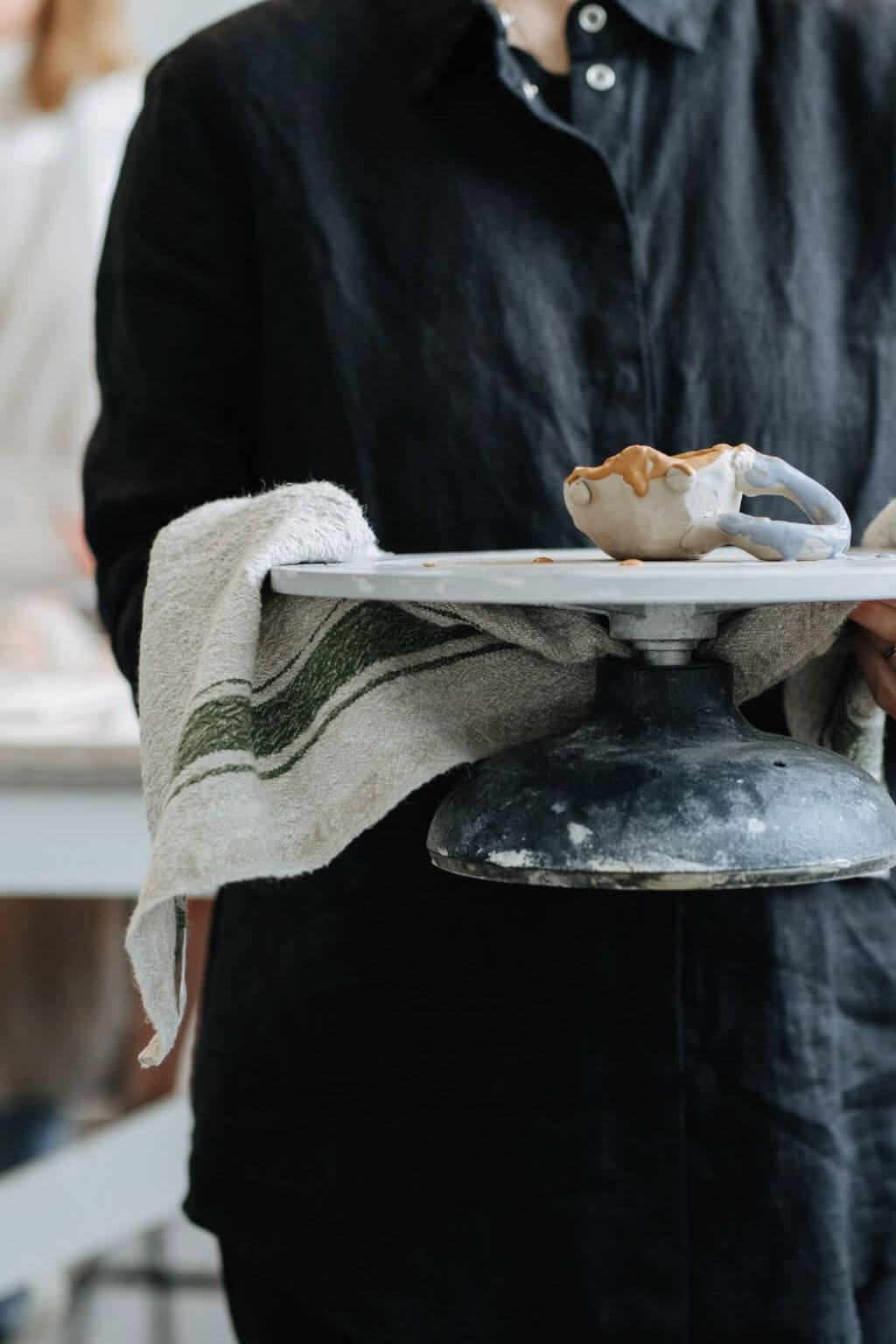 Green stripe linen kitchen towel draped over cake stand during serving