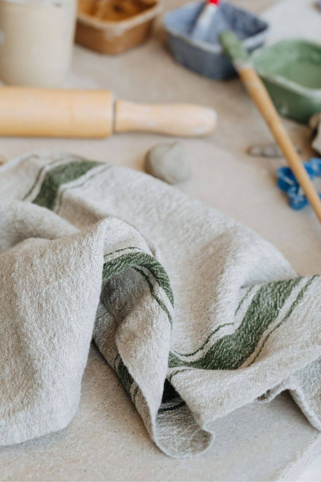 Soft washed green stripe linen kitchen towels folded on countertop