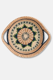Woven basket with decorative handles on a light gray background