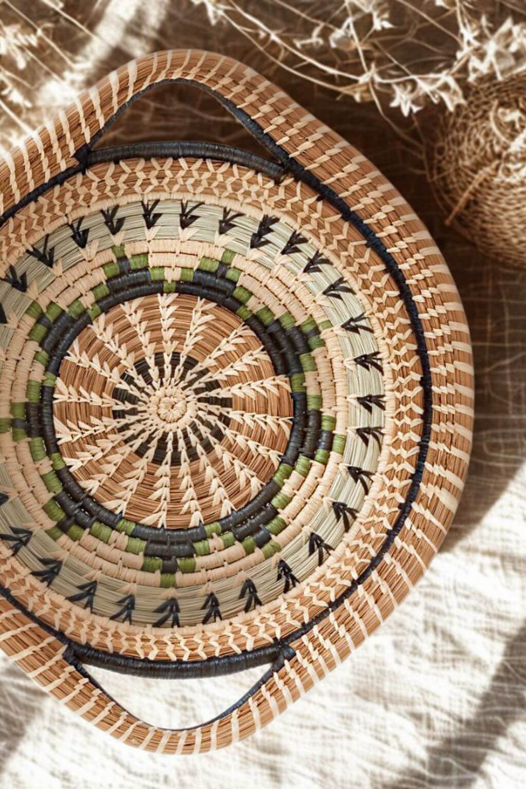 Woven basket with decorative patterns on a textured surface