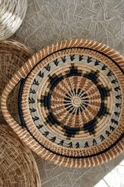 Woven basket with concentric circle pattern on a textured surface