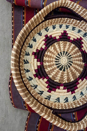 Woven basket with concentric circle pattern on a textured fabric background