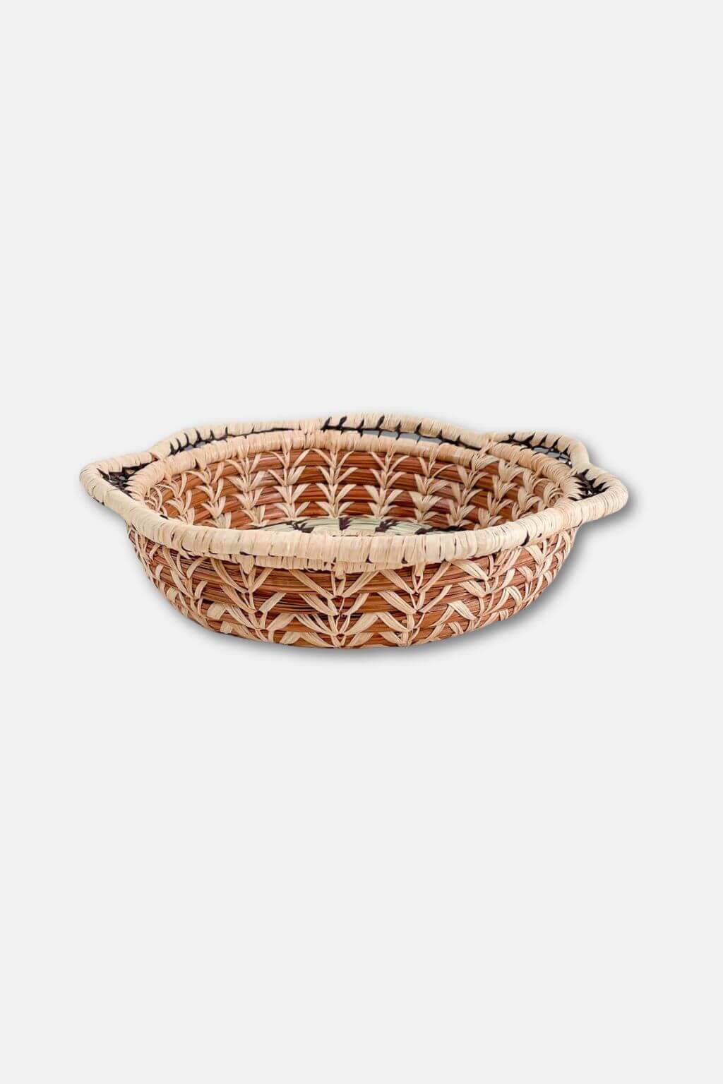 Woven bread basket with decorative patterns on a white background