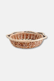Woven bread basket with decorative patterns on a white background
