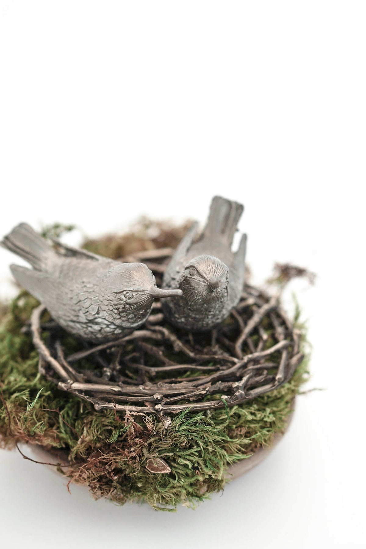 Antique pewter hummingbird shakers styled in nest with moss base