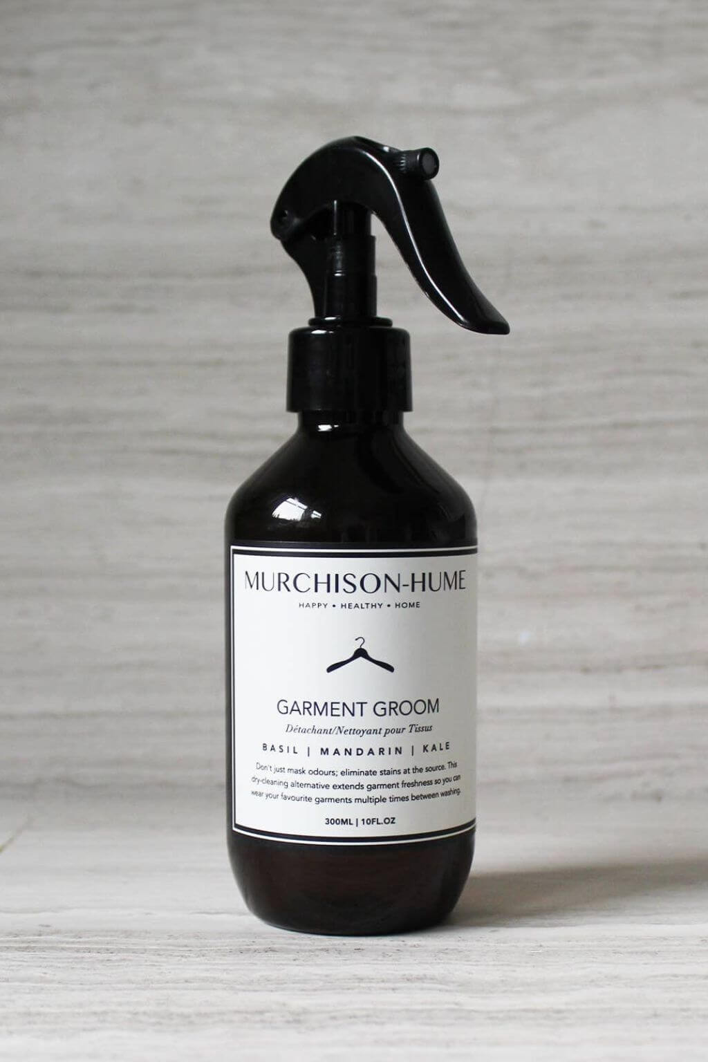 Amber spray bottle labeled 'Murchison-Hume Garment Groom' on a textured gray background