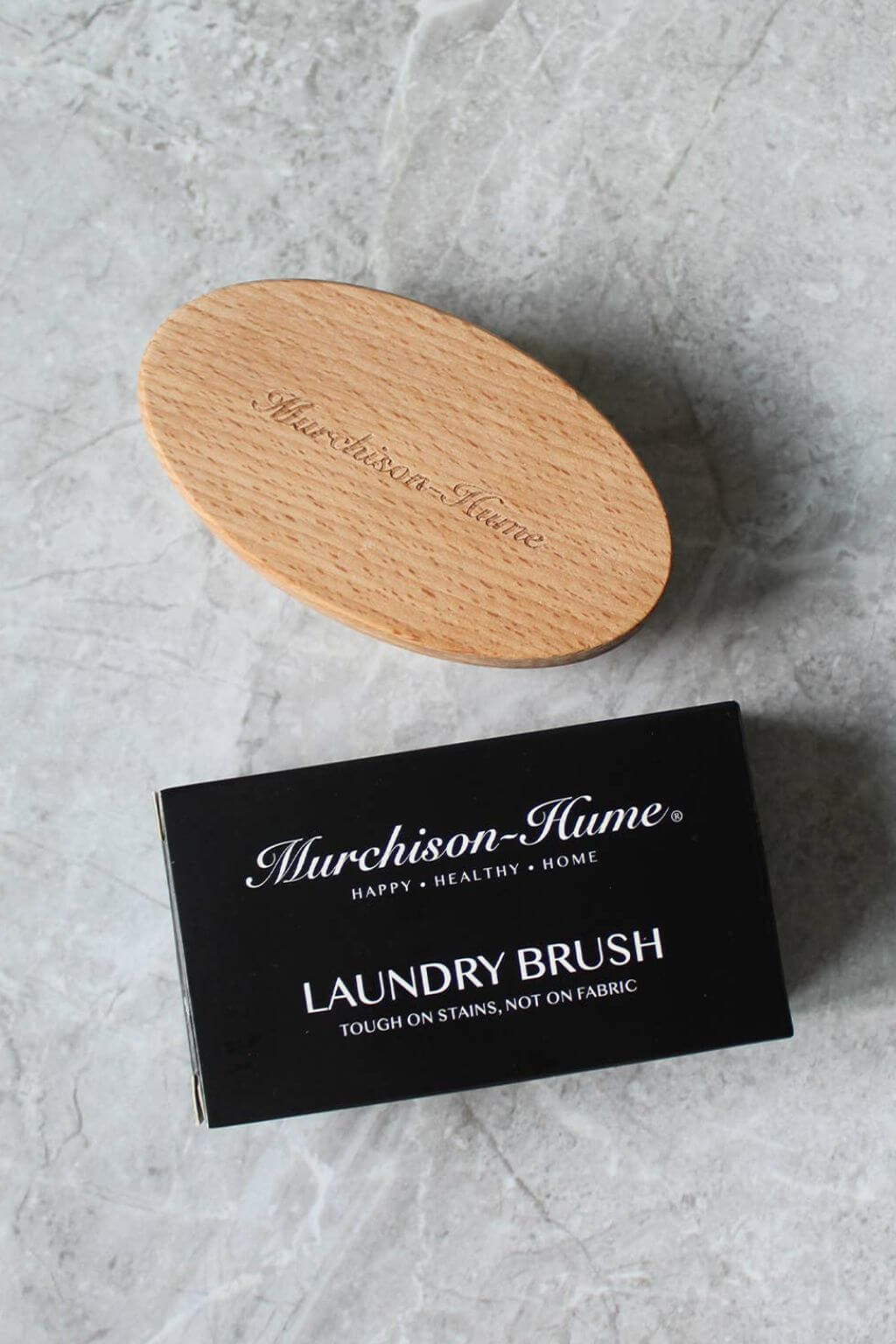 Murchison-Hume laundry brush on a gray surface