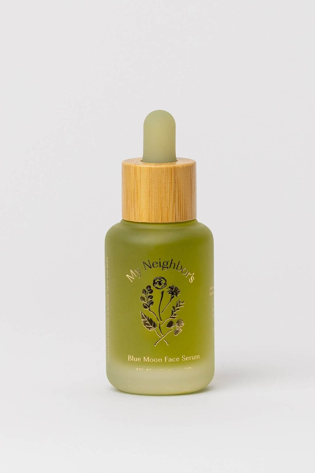 Green face serum bottle with bamboo cap on a white background