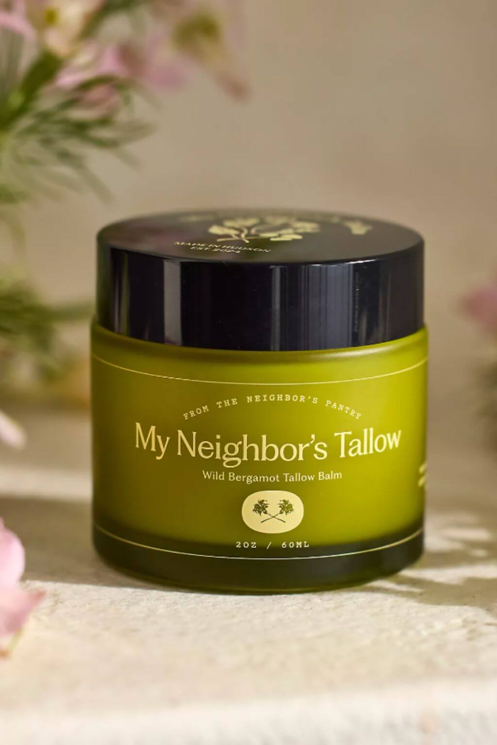 My Neighbor tallow balm styled with soft floral background