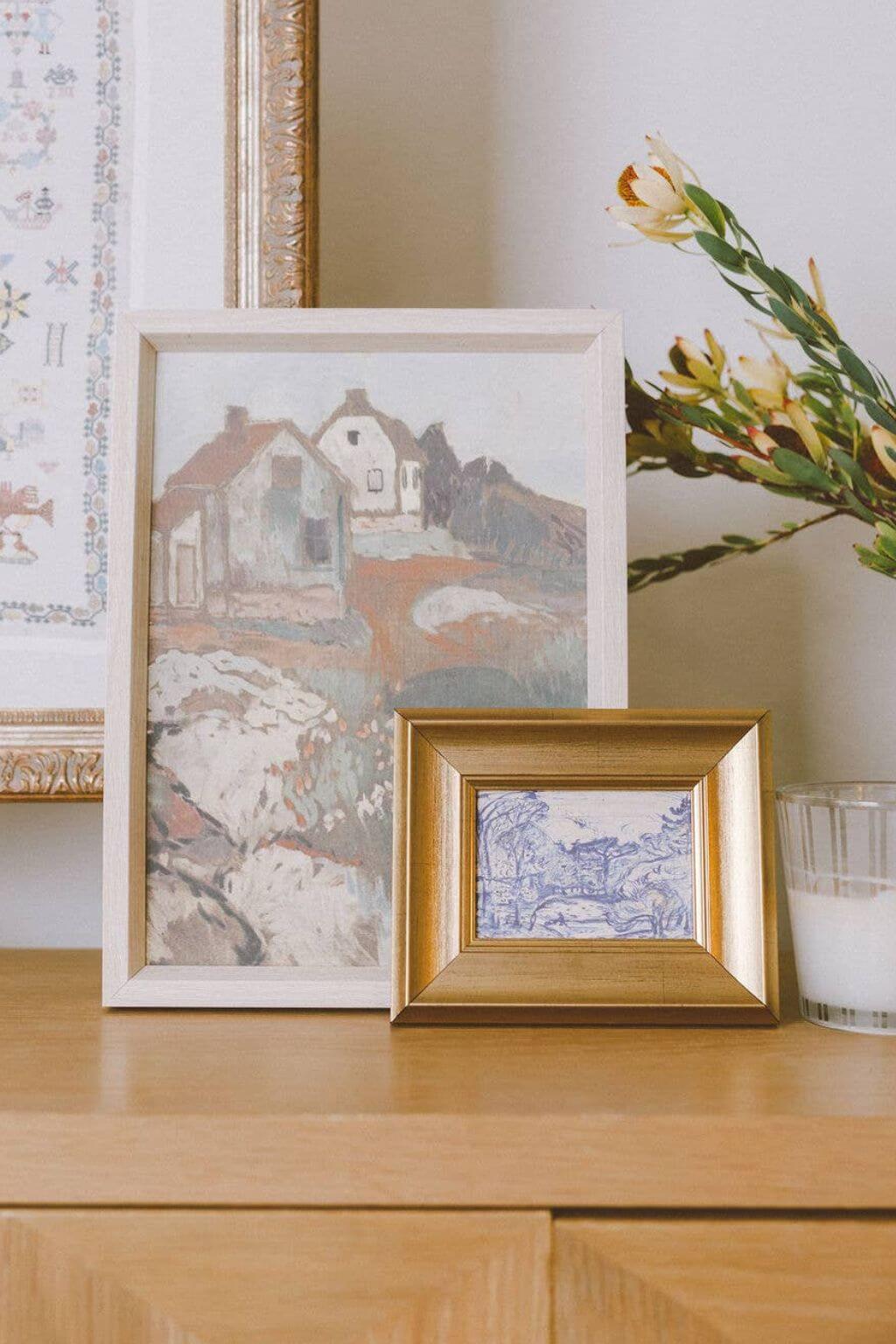 Vintage countryside cottages painting in ornate frame neutral tones