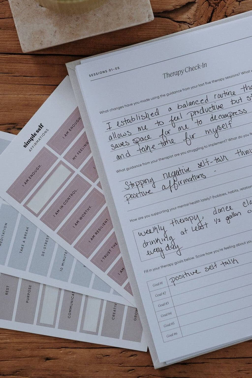 Therapy check-in sheet and planner stickers on a wooden surface