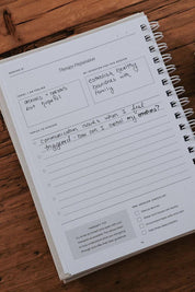 Notebook with therapy preparation worksheet on a wooden surface