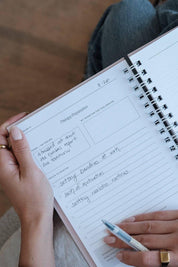 Person holding a spiral-bound notebook for Theraphy Preparation 
