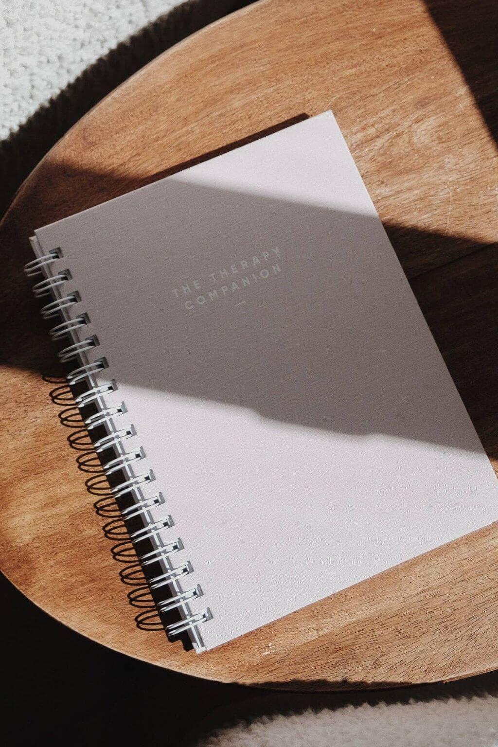 Spiral-bound Therapy Companion notebook on a wooden surface