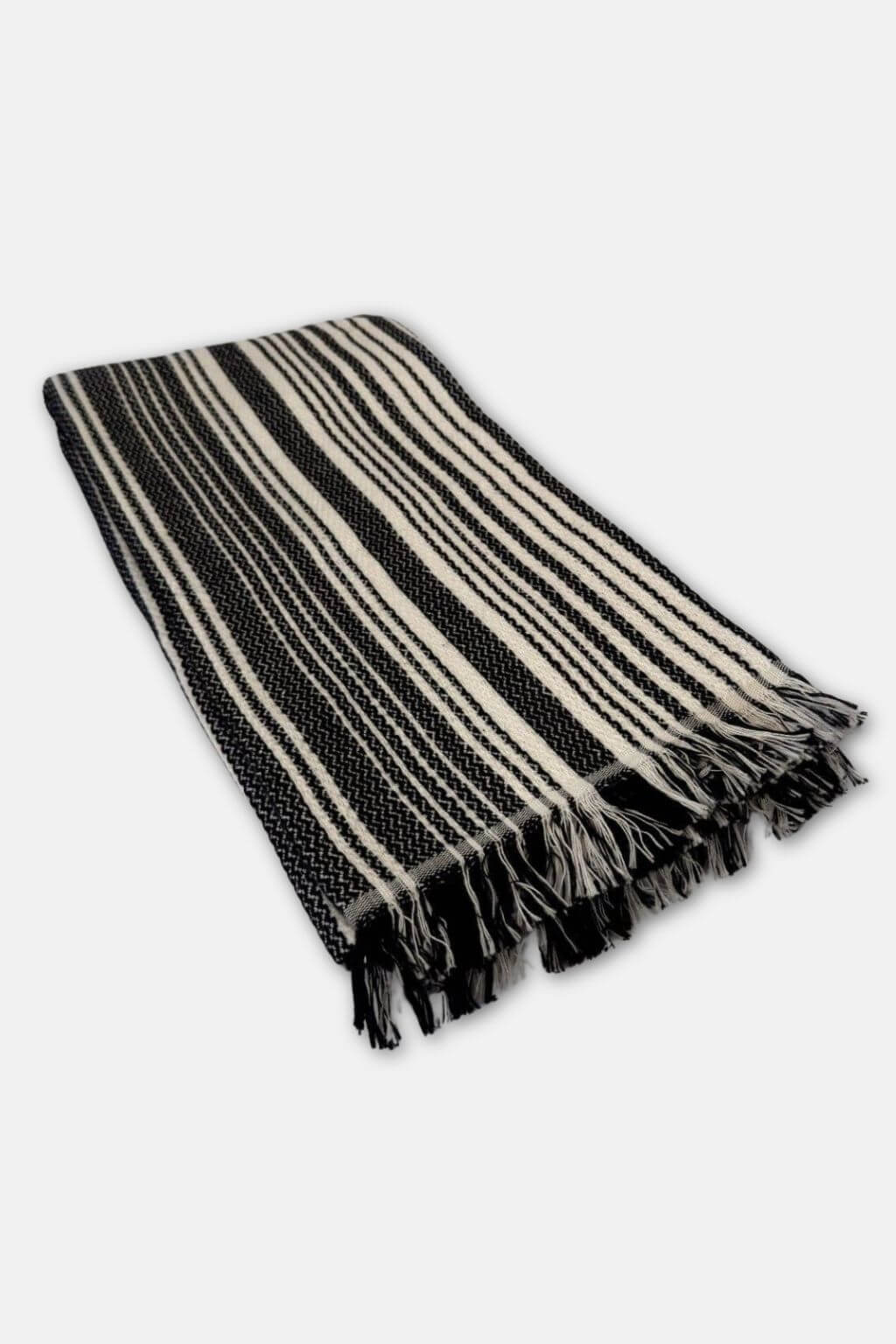 Black and cream striped towels with fringes on a white background