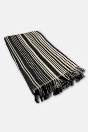 Black and cream striped towels with fringes on a white background