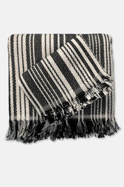 Black and cream striped towels with tassels on a white background
