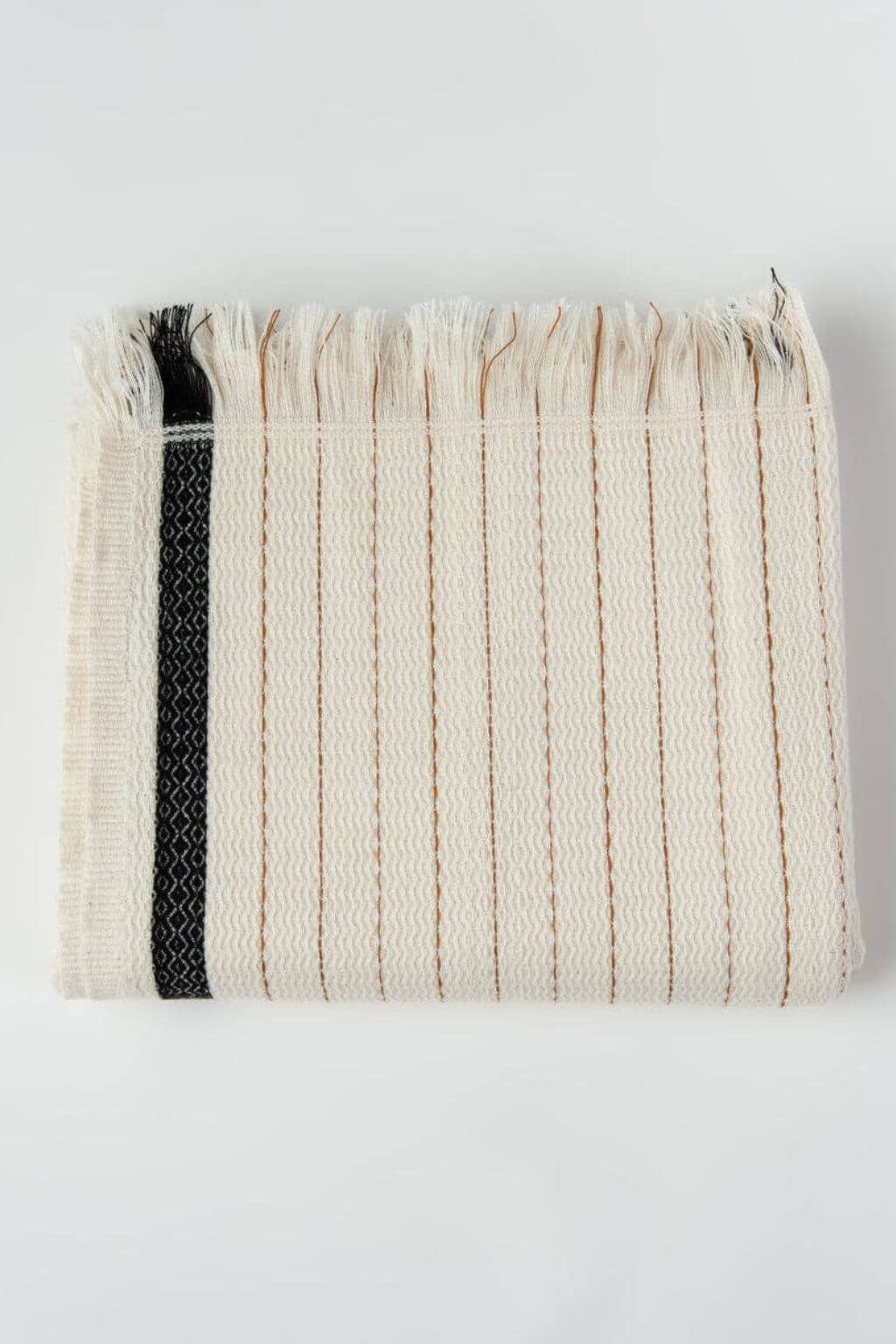 Folded woven towel with a black stripe on a white background