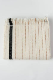 Folded woven towel with a black stripe on a white background