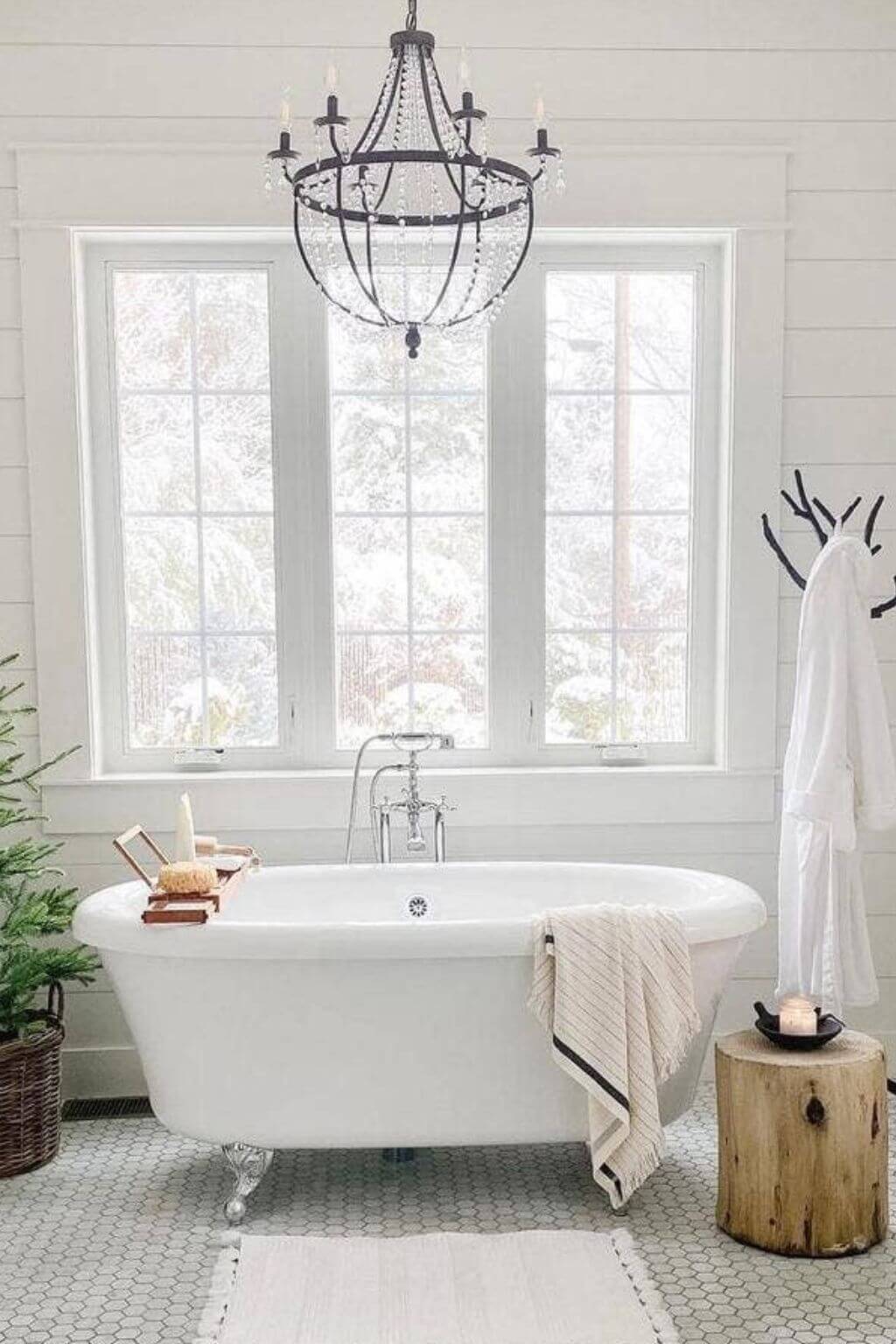 Bathroom with a freestanding bathtub, chandelier, and window