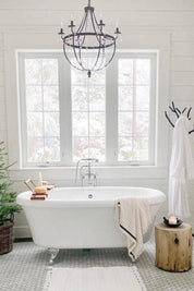 Bathroom with a freestanding bathtub, chandelier, and window