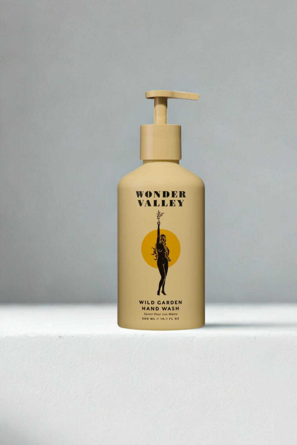 Wonder Valley Wild Garden Hand Wash in a beige pump bottle with a black and yellow label, set against a neutral gray background.