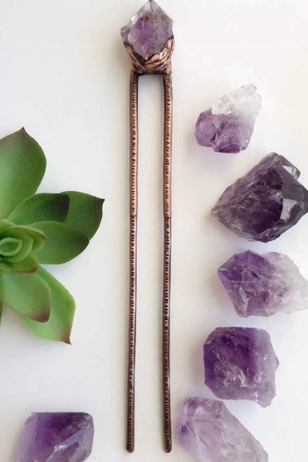 Amethyst crystal hair pins on a white background with succulent and additional crystals.