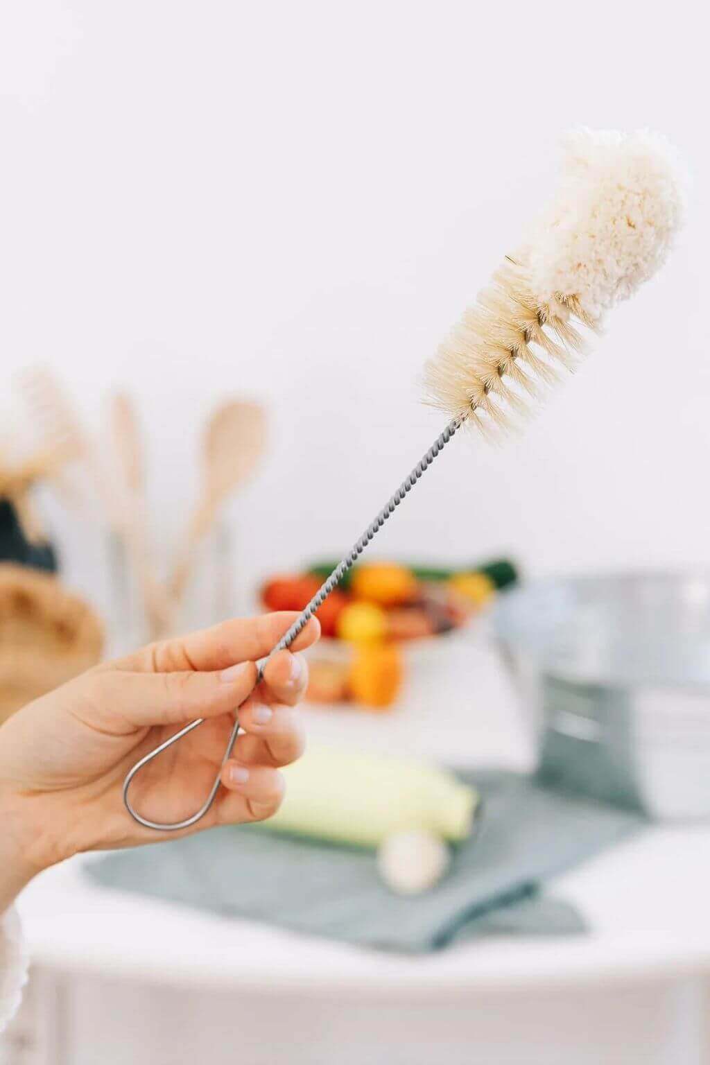 Slim bottle brush with natural bristles and looped handle, ideal for cleaning narrow-neck bottles and glassware