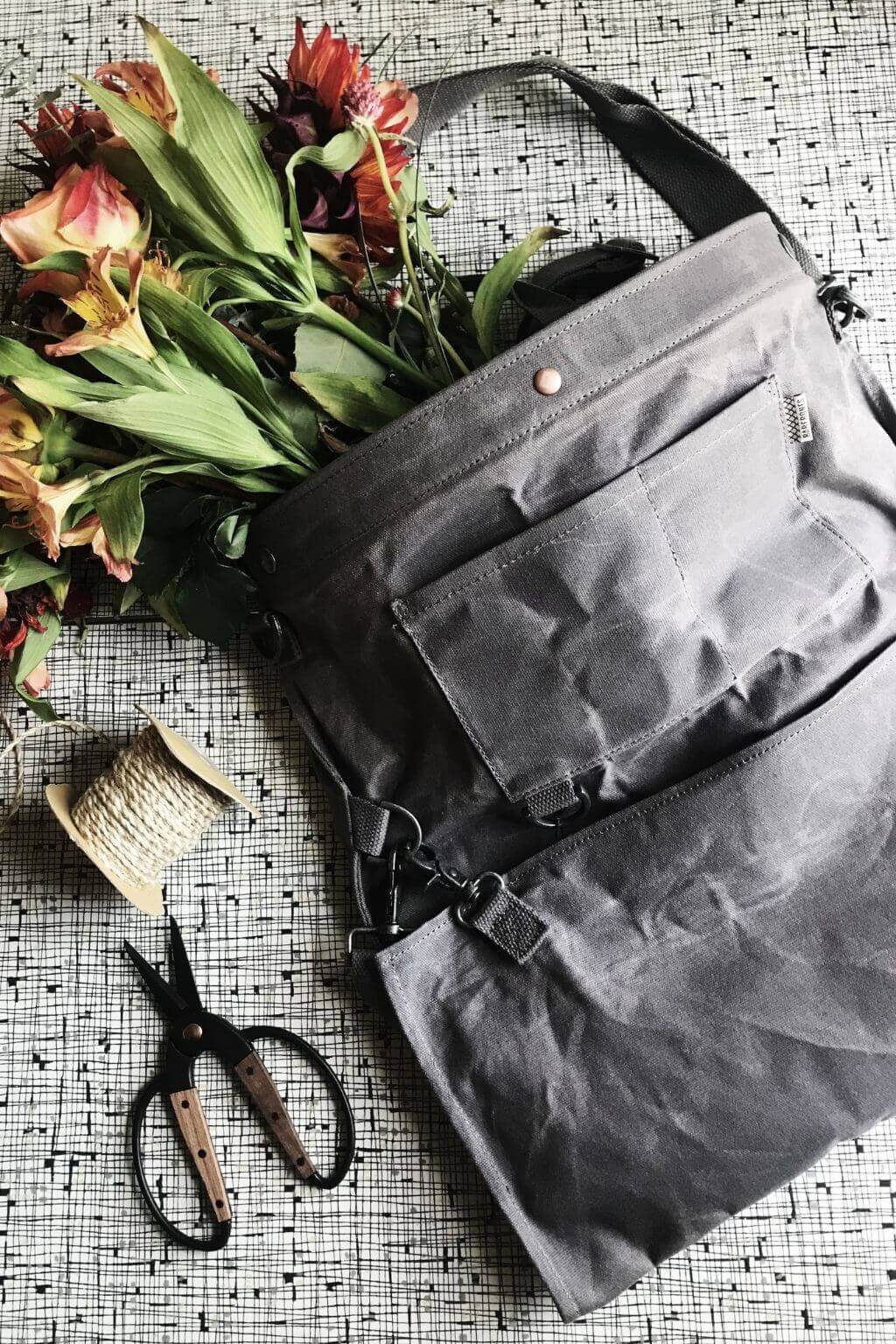Waxed canvas gathering bag with flowers and garden tools