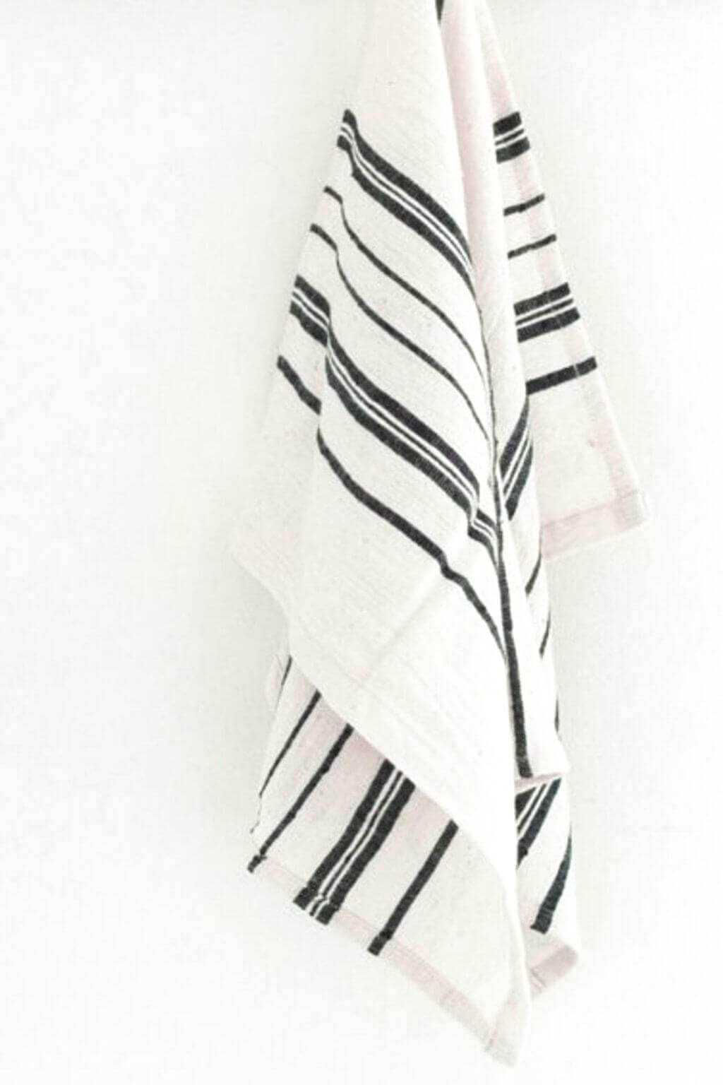 White tea towel with navy stripes on a white background