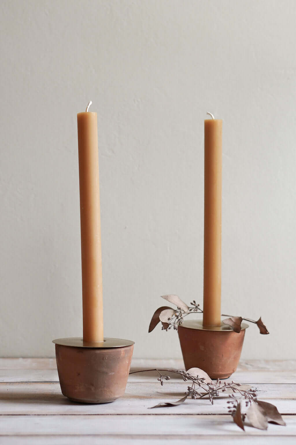 terracotta candle holder with brass insert holding taper candle