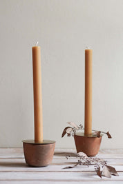 terracotta candle holder with brass insert holding taper candle