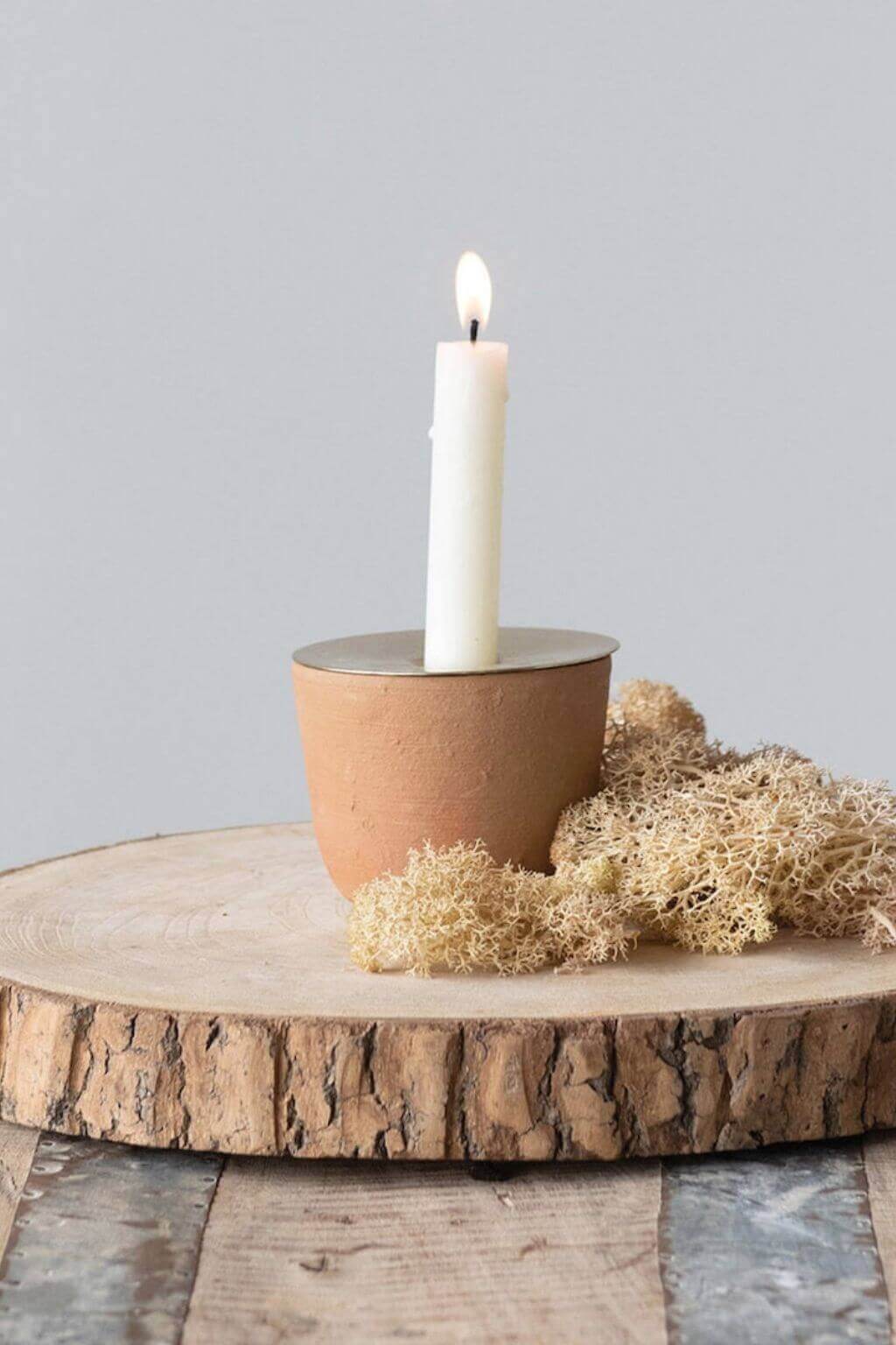 terracotta candle holder styled on wood slice with candle