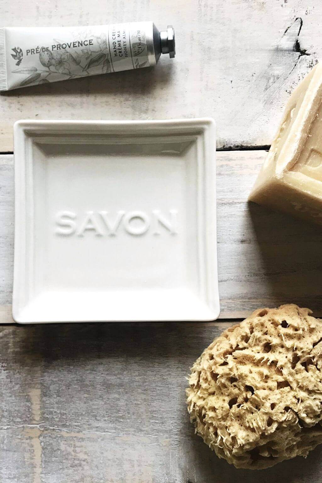 Close-up of embossed "Savon" lettering on ceramic soap dish