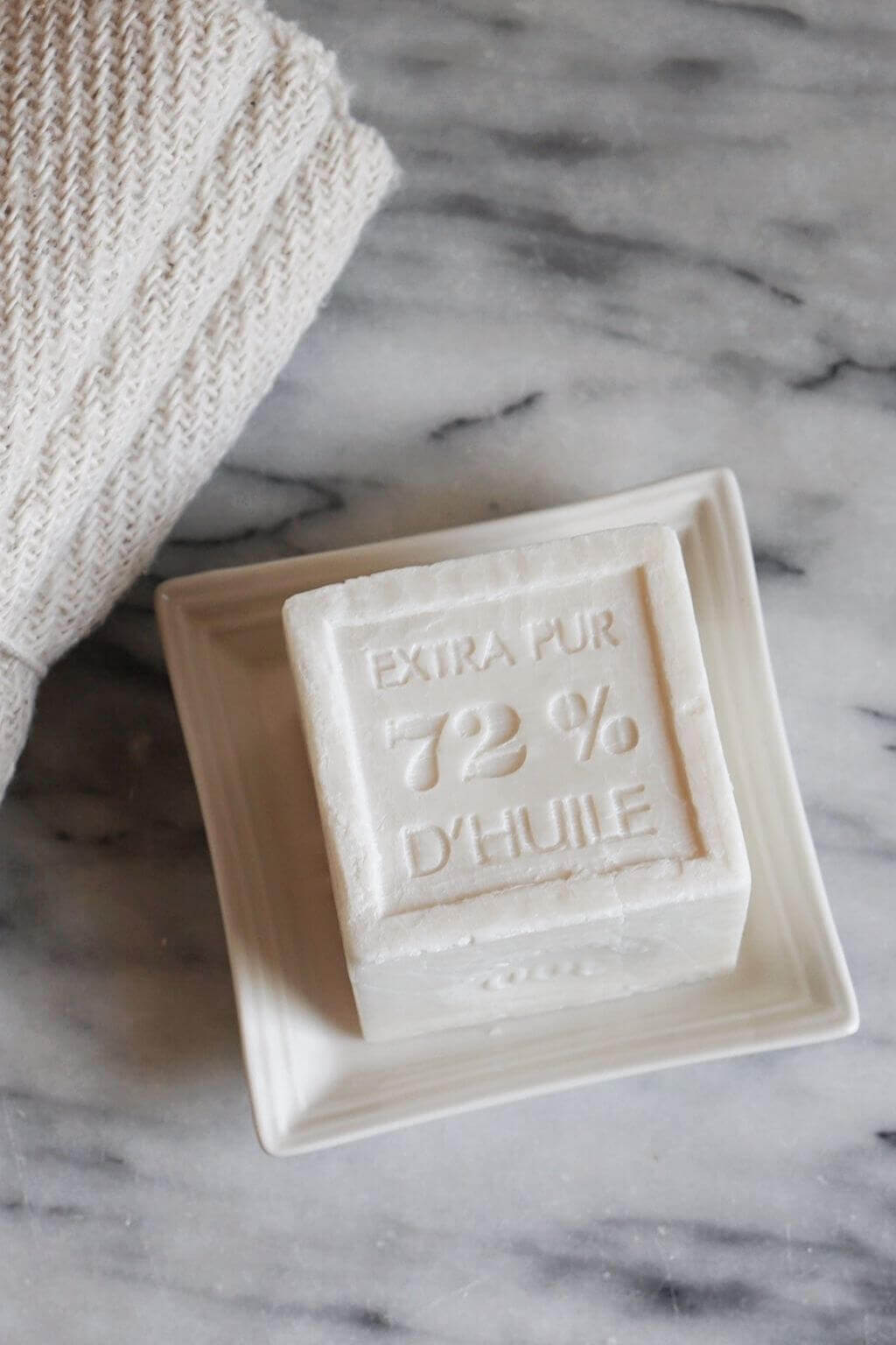 French ceramic soap dish styled in a bathroom with Marsseille Soap and textural washcloths