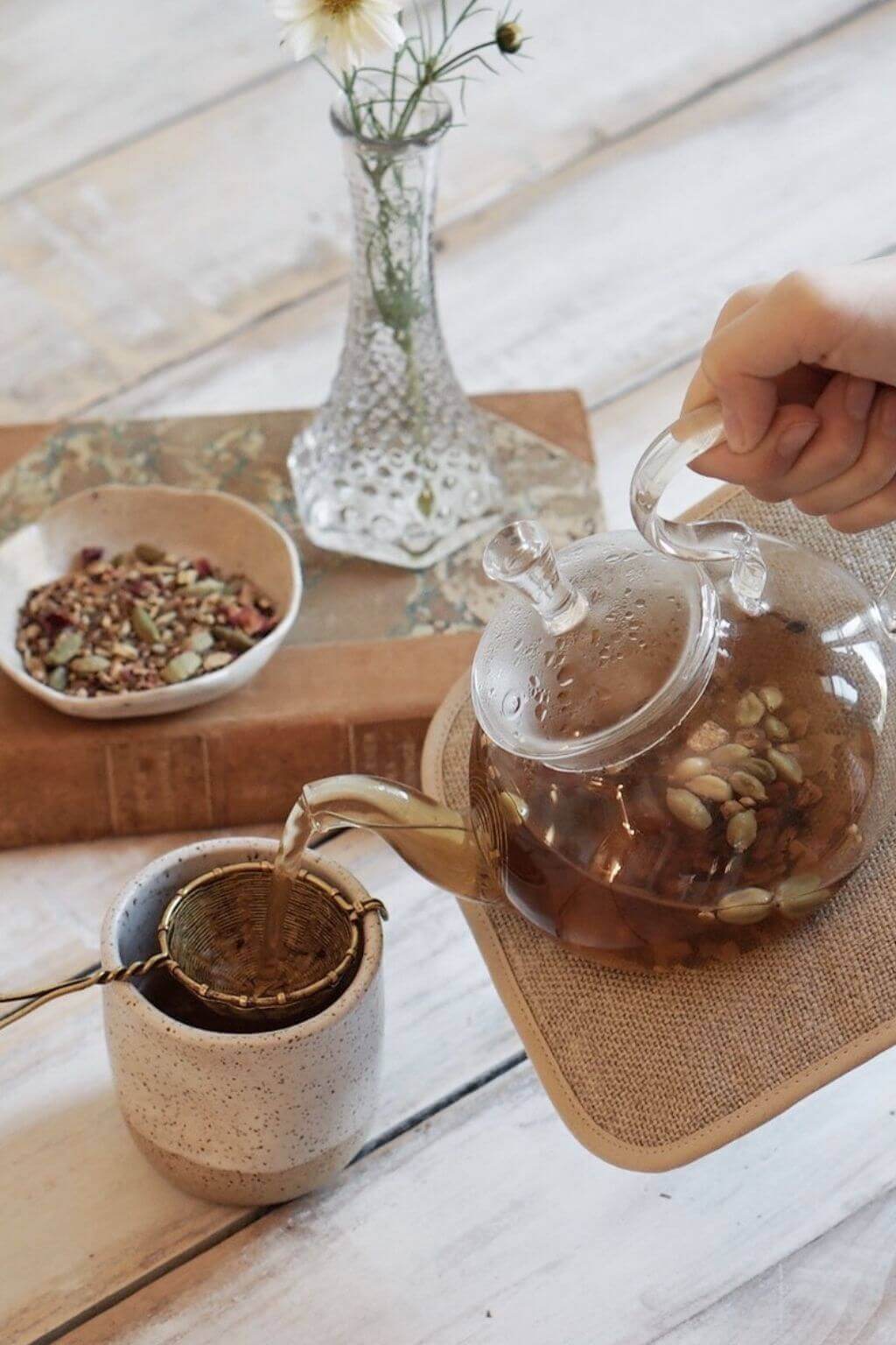 Handwoven brass tea strainer used to steep loose leaf tea from a glass teapot