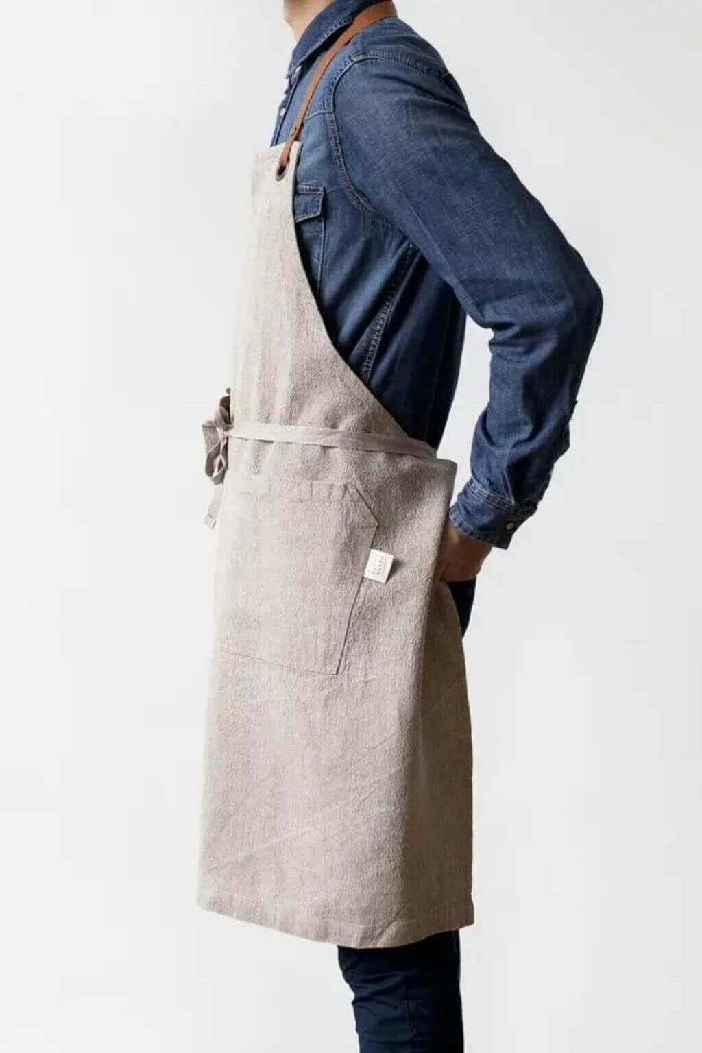 Side profile of natural linen apron with leather neck strap