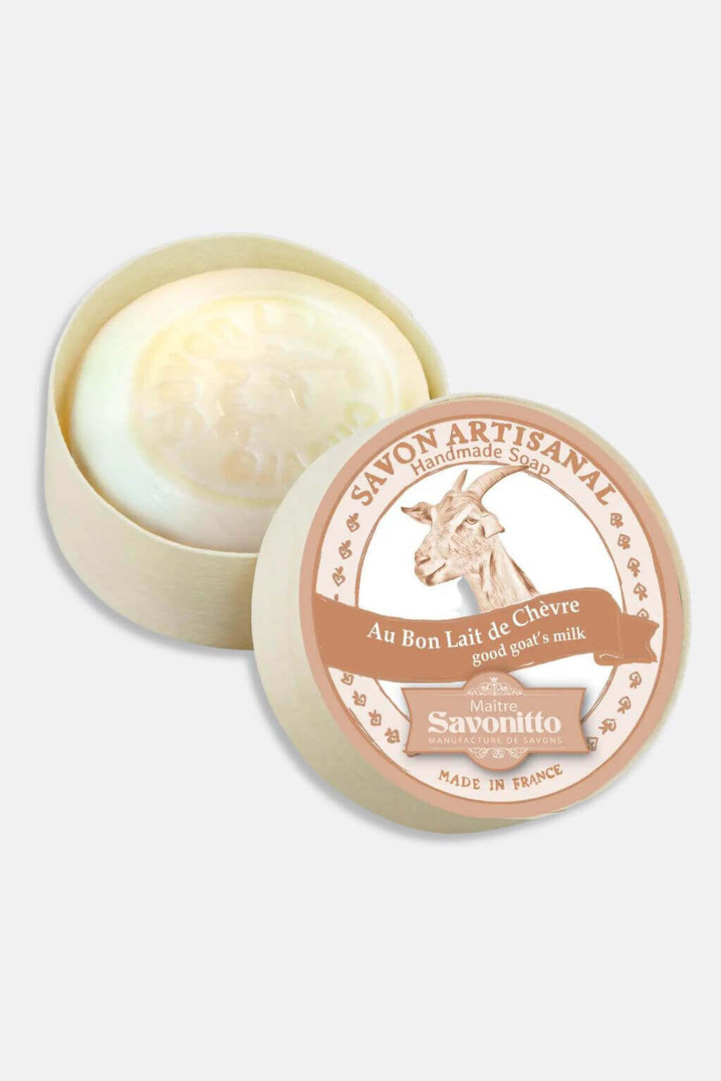 An open round beige tin of Savonitto artisanal goat milk soap, showing the pale cream-colored soap inside, with the matching lid placed beside it on a light gray background.