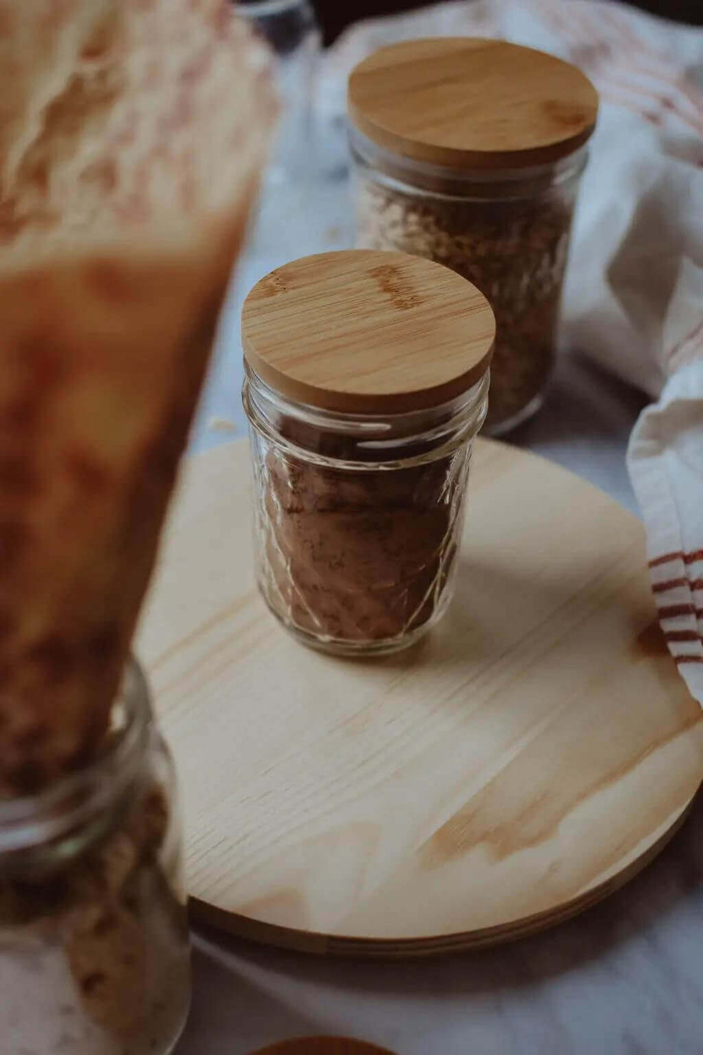 Glass jars with bamboo lids on a wooden surface